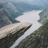 Breathtaking view of Trolltunga rock formation overlooking a serene fjord in Norway.