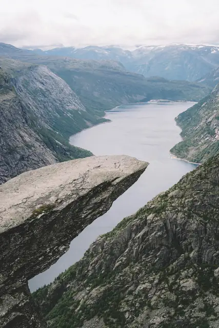 Breathtaking view of Trolltunga rock formation overlooking a serene fjord in Norway.