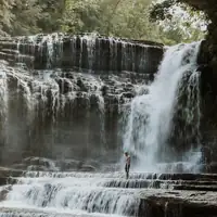 A stunning waterfall in Tennessee with a lone visitor experiencing its beauty.