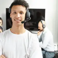 Smiling agents with headsets working in a bright, modern office environment.