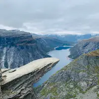 Breathtaking aerial view of the iconic Trolltunga rock formation overlooking a serene lake in Ullensvang, Norway.