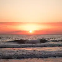 Tranquil sunrise over the ocean in Mersin, Türkiye with gentle waves and warm colors.