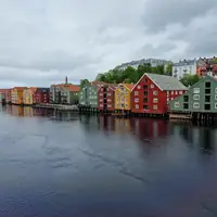 A vibrant view of colorful waterfront houses in Trondheim, Norway under overcast skies.